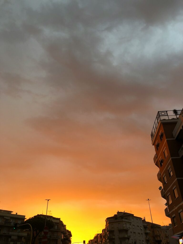 the sun is setting over a city with tall buildings