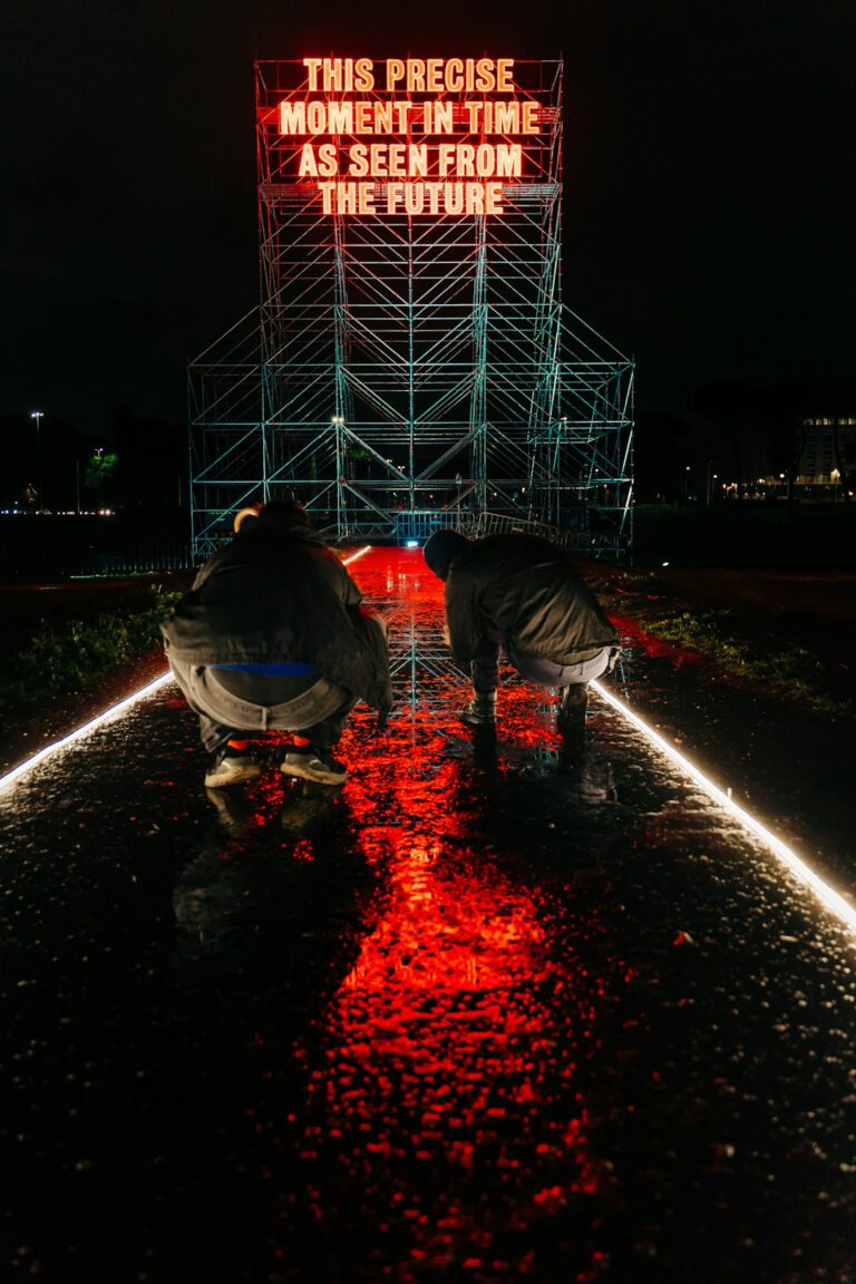 Photographers taking puddle pictures of visual artist's Tim Etchells 16-m tall neon istallazione in the Circus Maximus,...