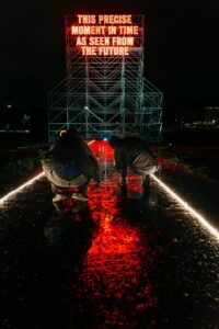 Photographers taking puddle pictures of visual artist's Tim Etchells 16-m tall neon istallazione in the Circus Maximus,...