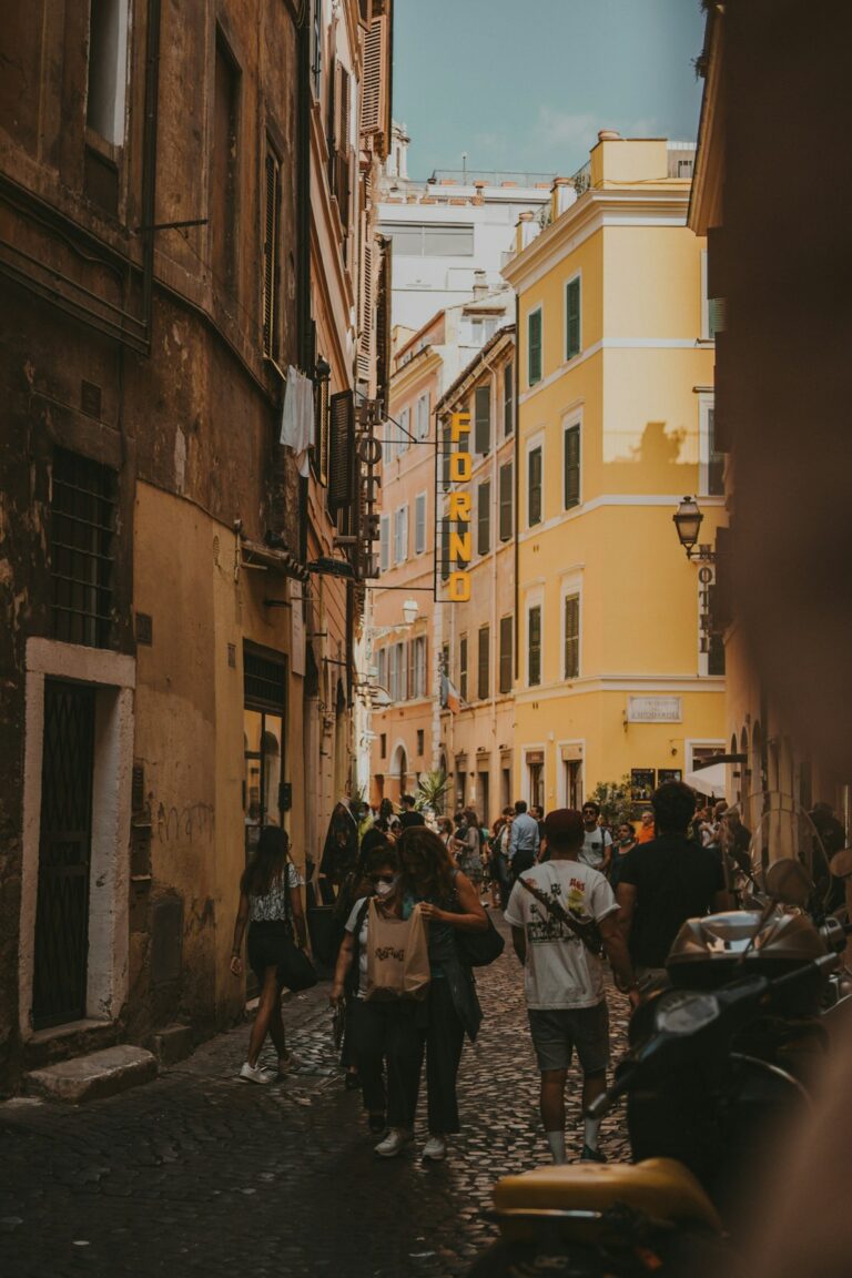 a group of people walking down a street next to tall buildings