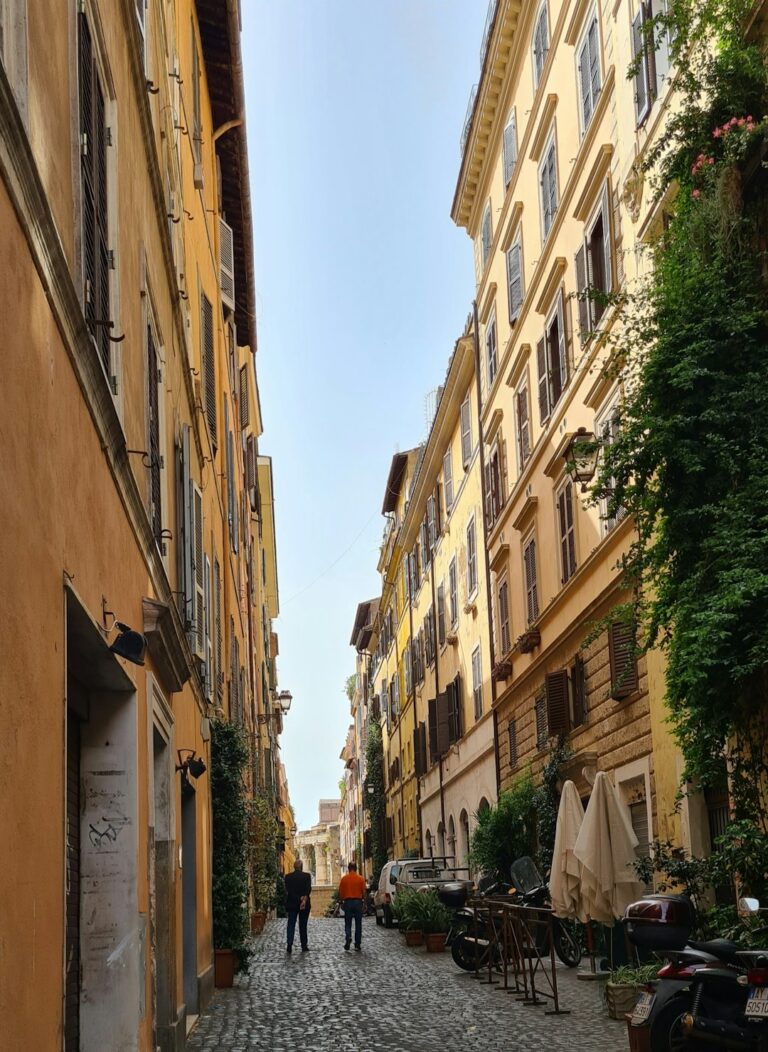 a couple of people walking down a cobblestone street