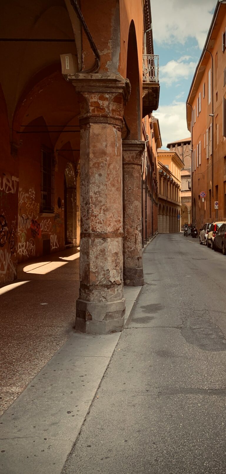 a narrow street with cars parked on both sides