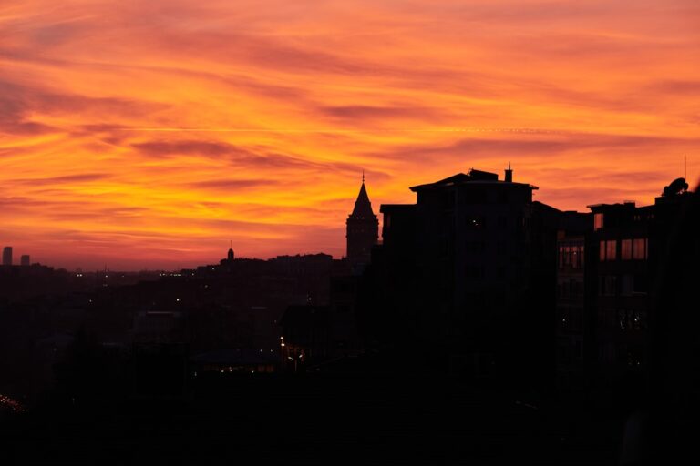 a sunset view of a city with buildings in the foreground
