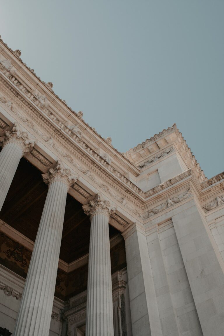 a tall building with columns and a sky background