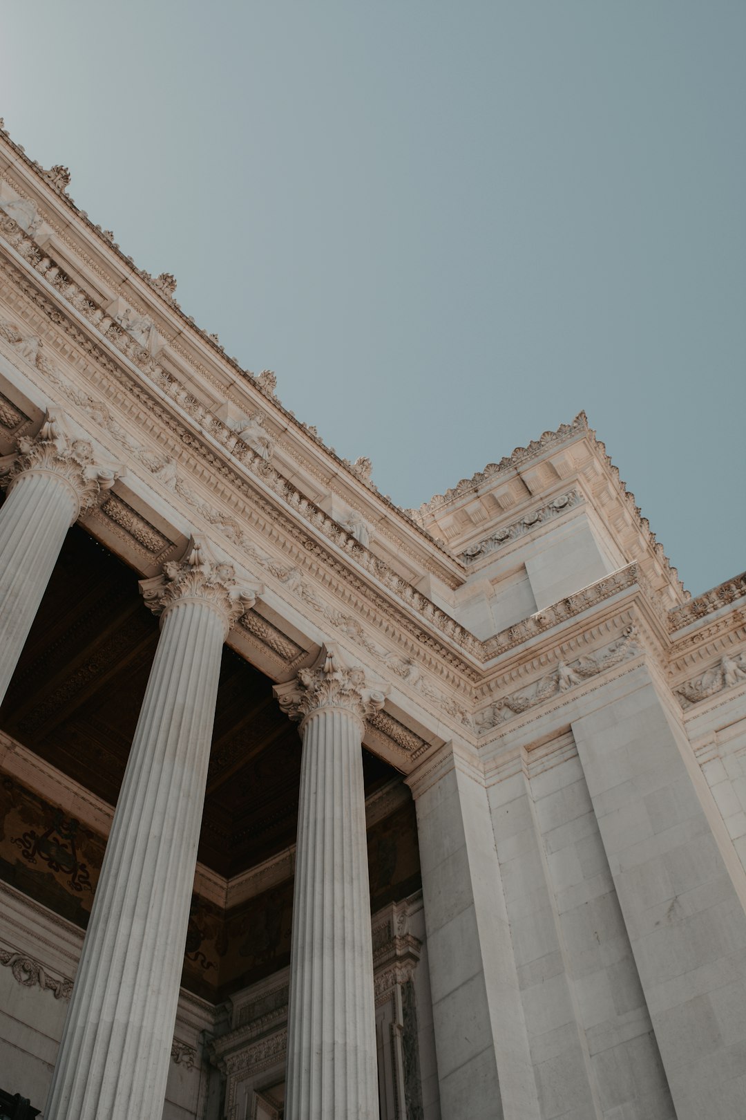 a tall building with columns and a sky background