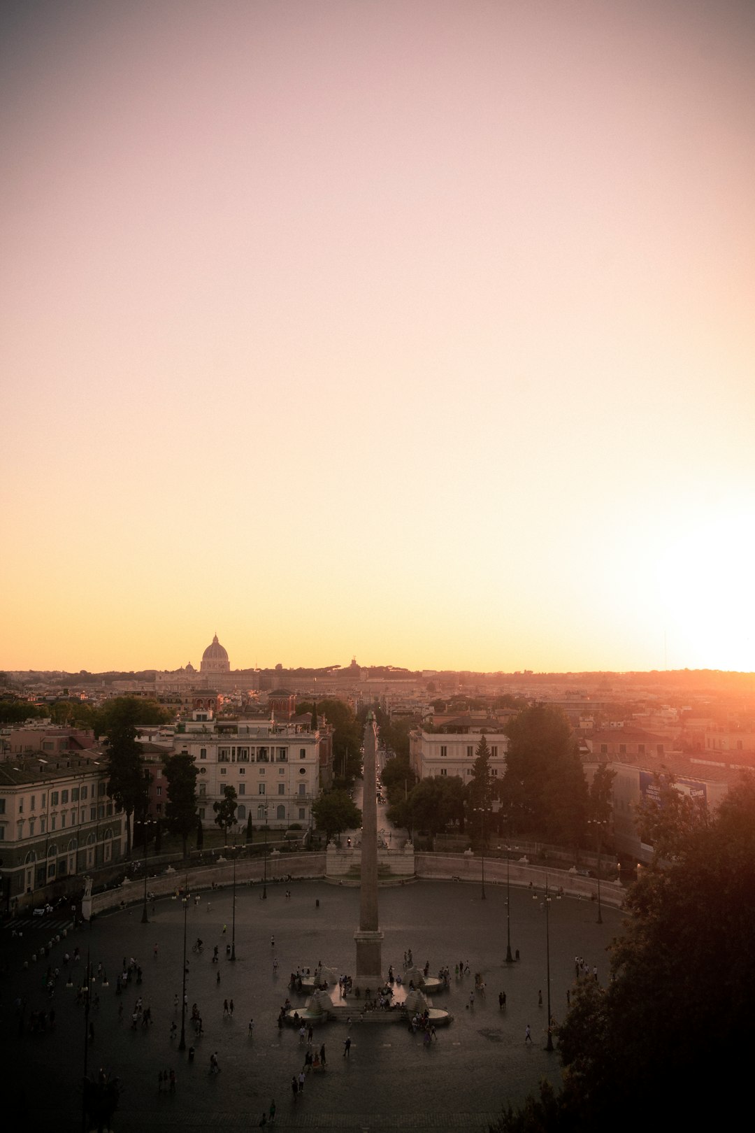 the sun is setting over a city square