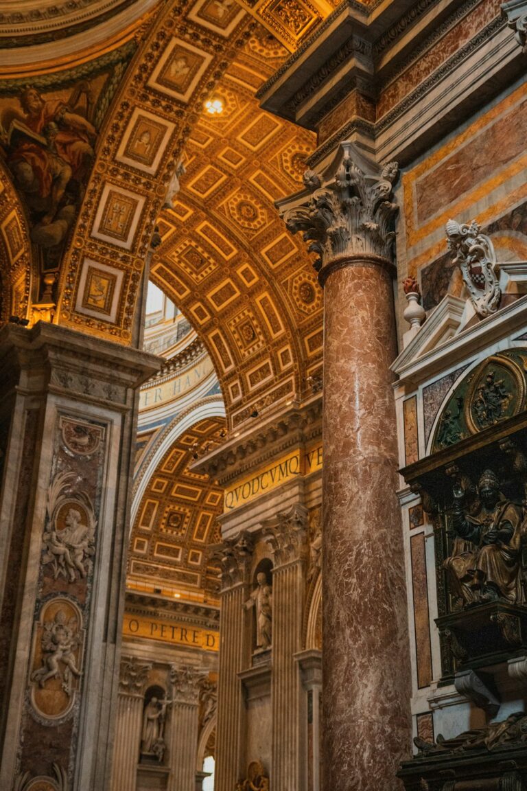 a large ornate building with columns and paintings on the walls