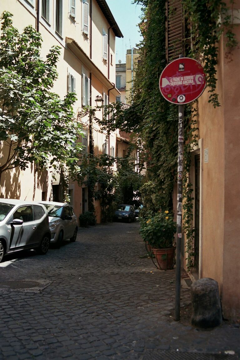 A red street sign sitting on the side of a building