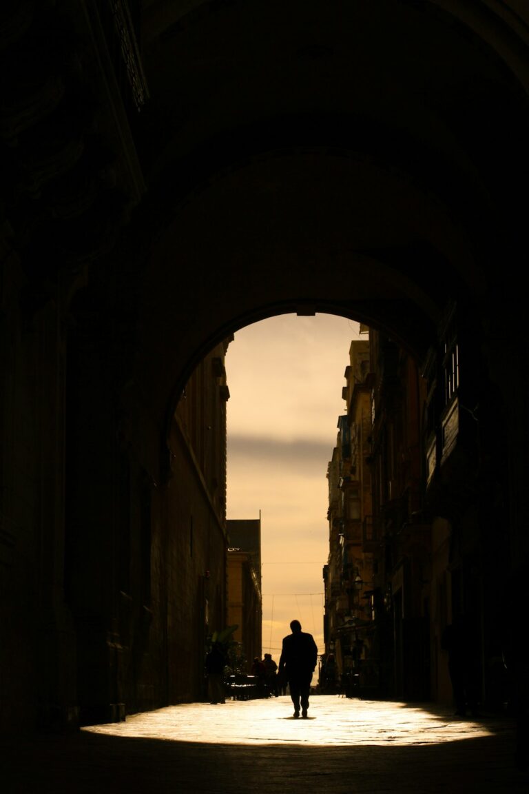 A silhouette of a person walking down a street