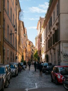 A narrow city street lined with parked cars