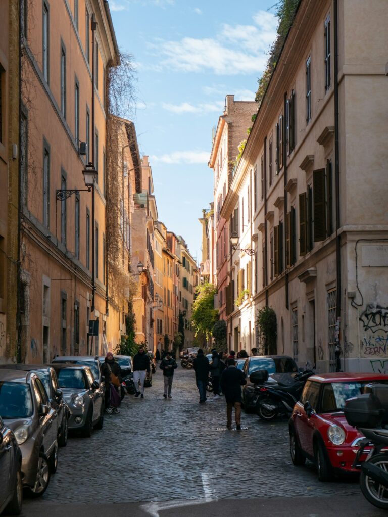 A narrow city street lined with parked cars