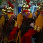 Roman soldiers marching in formation with vibrant uniforms.