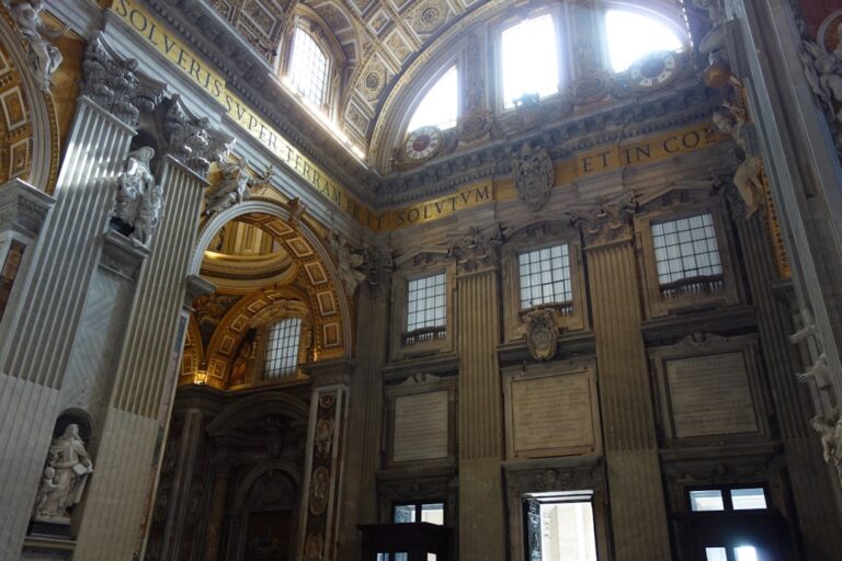 Interior of a grand, ornate building with arched windows.