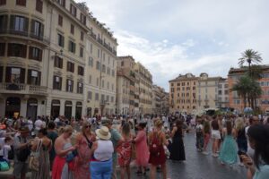 Crowded european square with historic buildings and palm trees